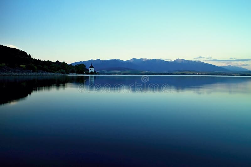 Mirroring on the water surface of Liptovska Mara at dusk.