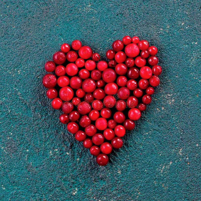 Mirtillo rosso nella forma del cuore su fondo verde fotografia stock libera da diritti Mirtillo rosso nella forma del cuore su fondo verde fotografia stock libera da diritti