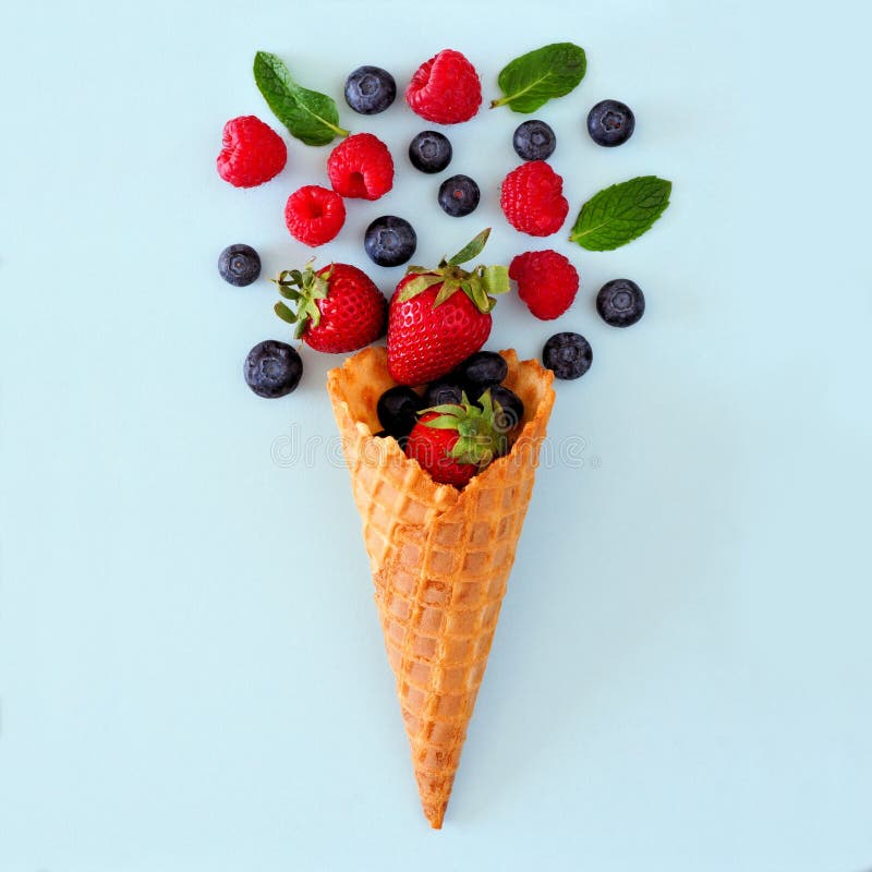 Mischbeeren in der Eistüte Flache Lage über einem blauen Hintergrund lizenzfreie stockfotos Mischbeeren in der Eistüte Flache Lage über einem blauen Hintergrund lizenzfreie stockfotos