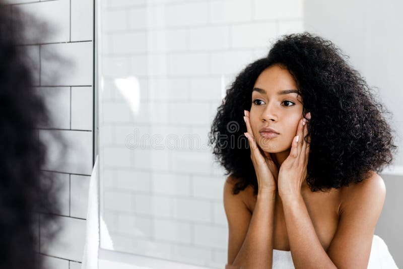 Mischrassefrau, die ihr Gesicht massiert stockfoto Mischrassefrau, die ihr Gesicht massiert stockfoto