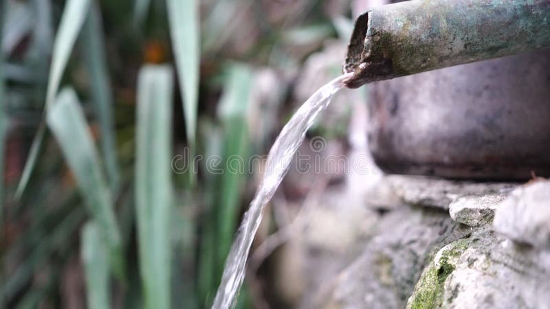 Mise au point sélective. l'eau de source s'écoule d'un tuyau métallique. images rapprochées d'un flux de pur pur frais potable banque de vidéos