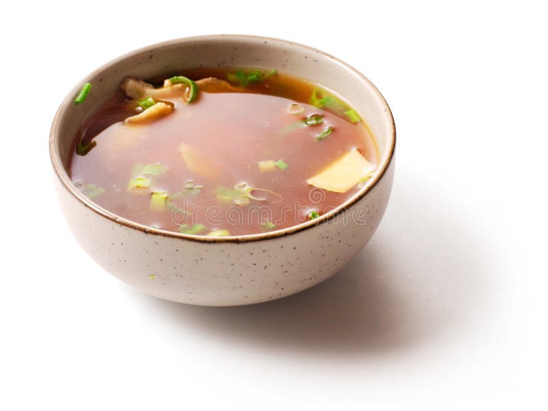 Miso soup with green onion in small dish over white