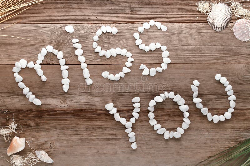 Miss You Love Words Written in Pebbles on Old Wood