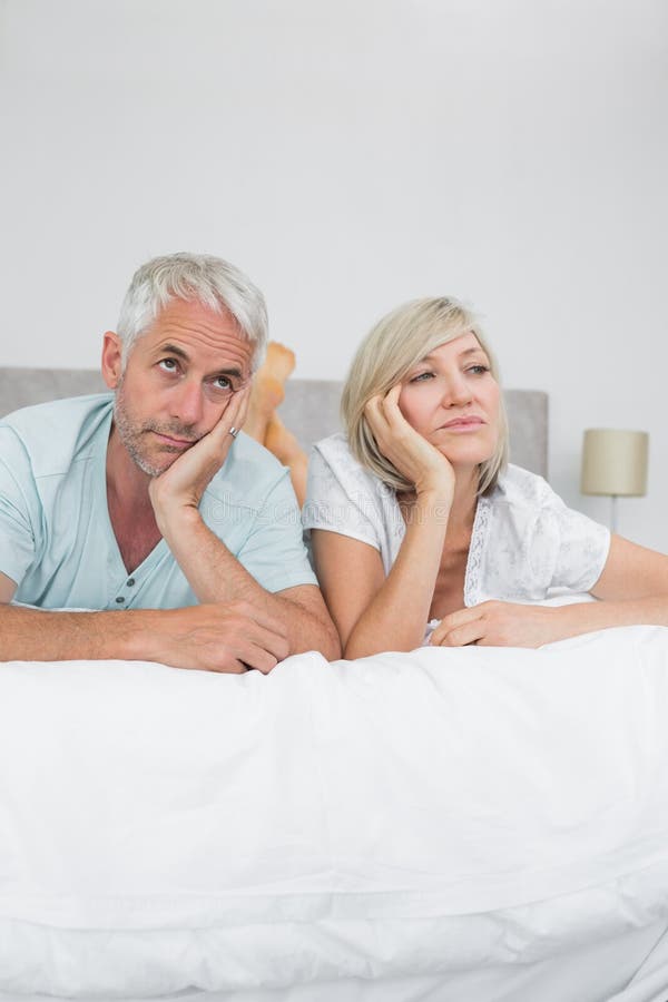 Missfallener reifer Mann und Frau, die im Bett liegt stockfotos Missfallener reifer Mann und Frau, die im Bett liegt stockfotos