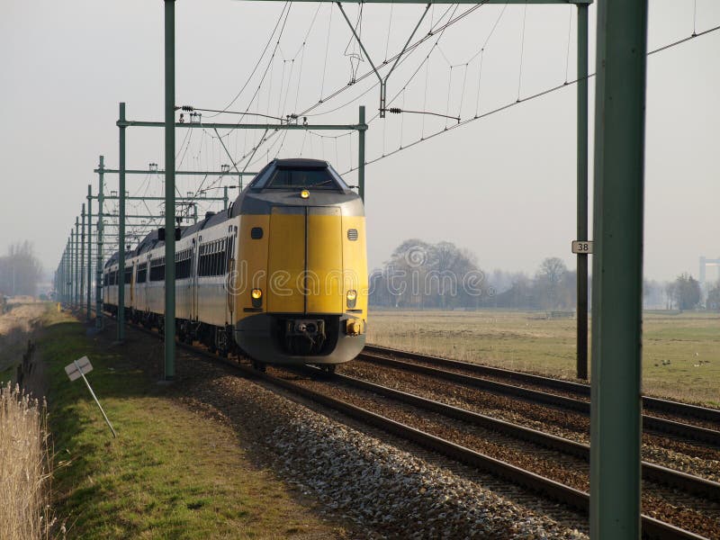 Missile aux performances améliorées interurbain Koploper de train sur la voie ferrée entre le Gouda et Rotterdam au croisement de photos libres de droits Missile aux performances améliorées interurbain Koploper de train sur la voie ferrée entre le Gouda et Rotterdam au croisement de photos libres de droits
