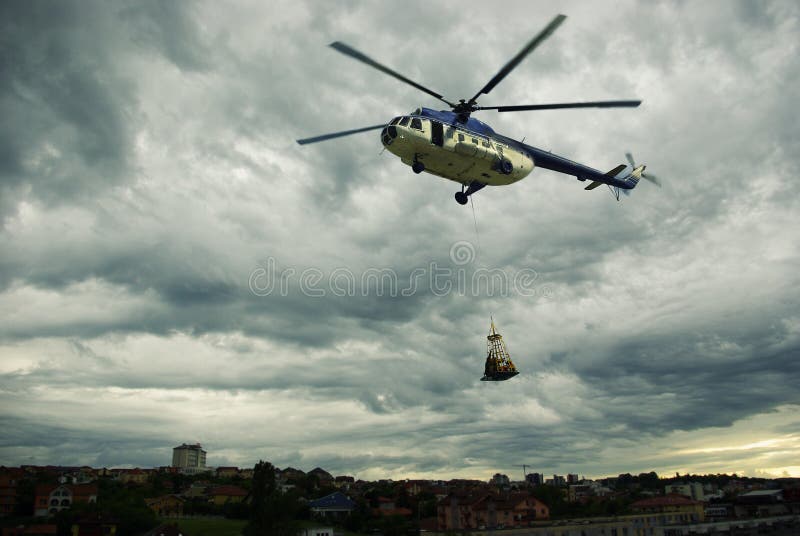 Helicopter rescuing people from the heavy storm approaching the city. Helicopter rescuing people from the heavy storm approaching the city.