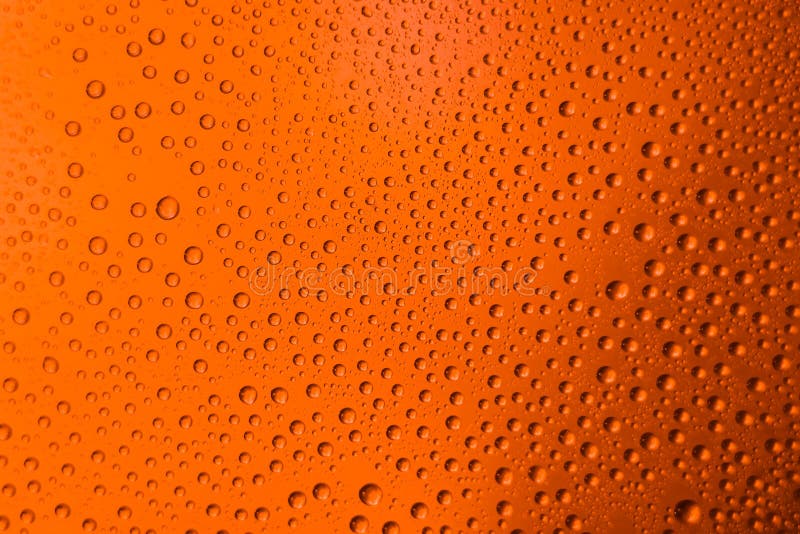 misted glass of beer close up an orange bright background