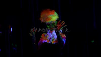 Misteriosa Mujer Con Pintura Fluorescente En Cara Y Cuerpo Moviéndose  Lentamente En La Oscuridad Metrajes - Vídeo de color, oscuridad: 219944112