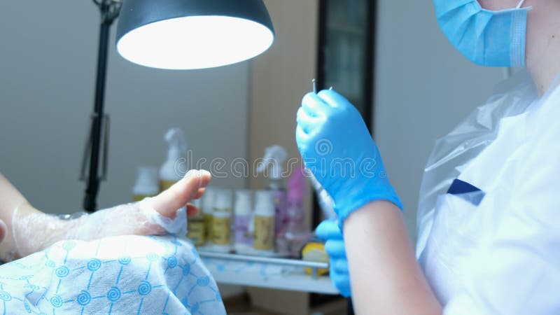 Mistrz w rękawiczkach wkłada nozzle w manicure maszynę fotografia stock Mistrz w rękawiczkach wkłada nozzle w manicure maszynę fotografia stock