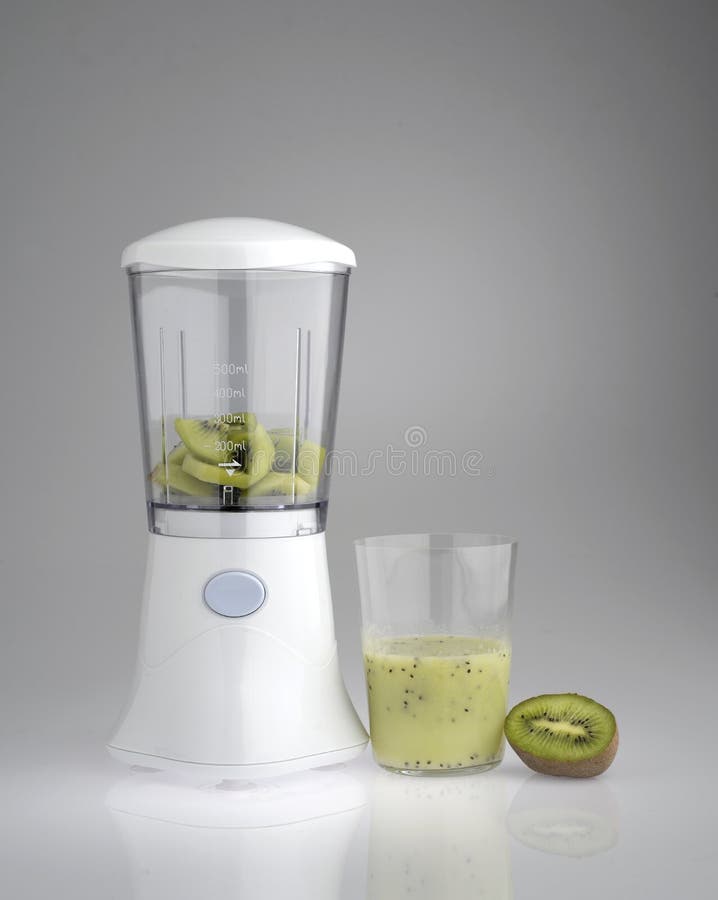 Glass of kiwi juice with a blender in action. Glass of kiwi juice with a blender in action