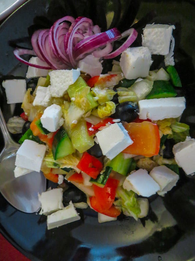 Misture a salada das folhas com a pimenta roasted e descascada do tomate, de sino, e o queijo de feta vestido com azeite, alho, e imagens de stock Misture a salada das folhas com a pimenta roasted e descascada do tomate, de sino, e o queijo de feta vestido com azeite, alho, e imagens de stock
