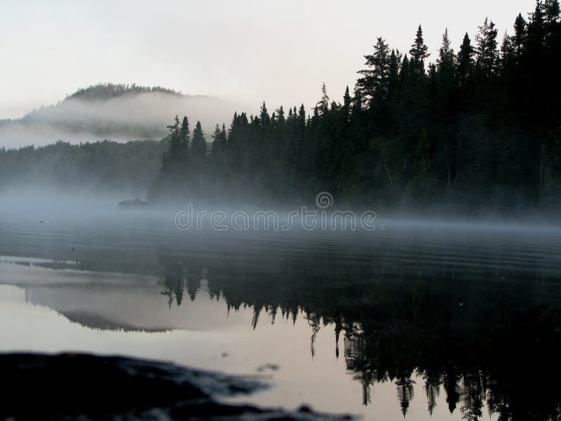 Calmante, di prima mattina di nebbia in aumento, un'altra splendida giornata inizia avventura canoa Mistinikin Lago, a Nord dell'Ontario.