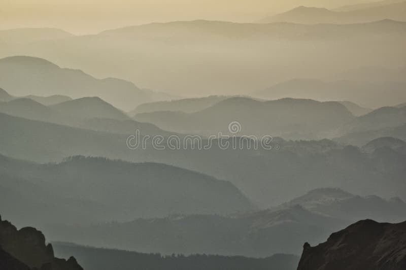 Misty Layers of Rolling Hills Under a Soft Golden Sky