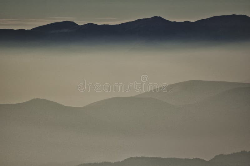 Misty Layers of Rolling Hills Under a Soft Golden Sky