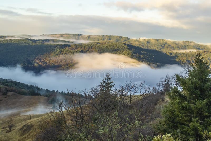 Misty Mountains - la vista fuori sopra le montagne e la nebbia ha riempito la valle nella California del Nord fotografia stock libera da diritti Misty Mountains - la vista fuori sopra le montagne e la nebbia ha riempito la valle nella California del Nord fotografia stock libera da diritti
