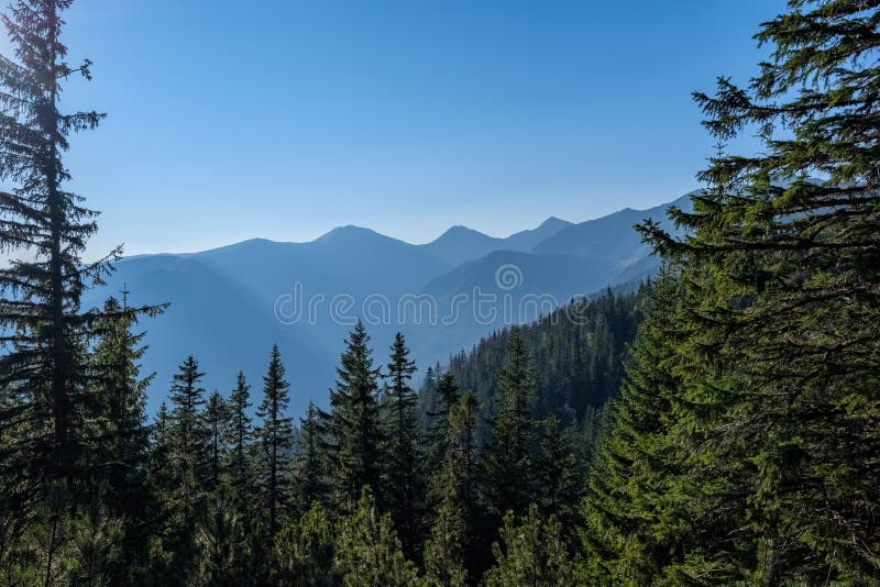 Misty sunrise in Slovakian Tatra mountains with light lanes in f