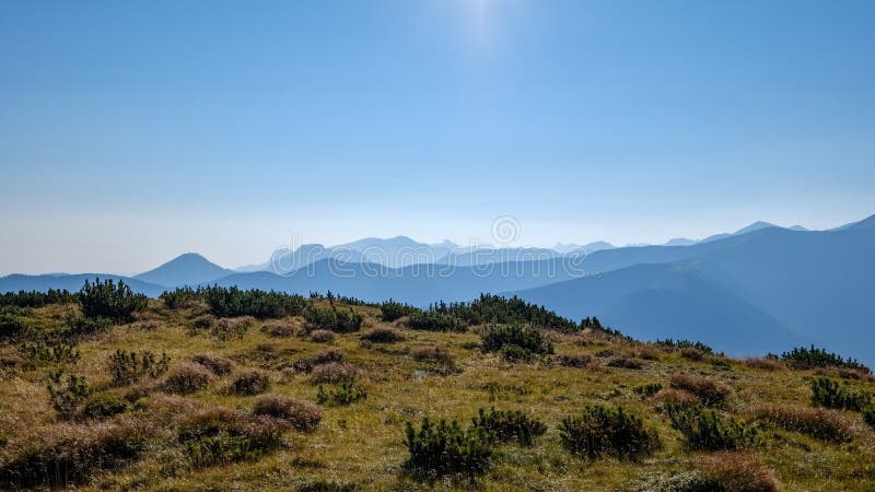 Mlhavé svítání ve slovenských Tatrách se světlými pruhy v f