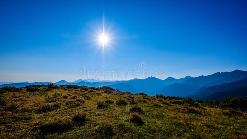 Mlhavé svítání ve slovenských Tatrách se světlými pruhy v f