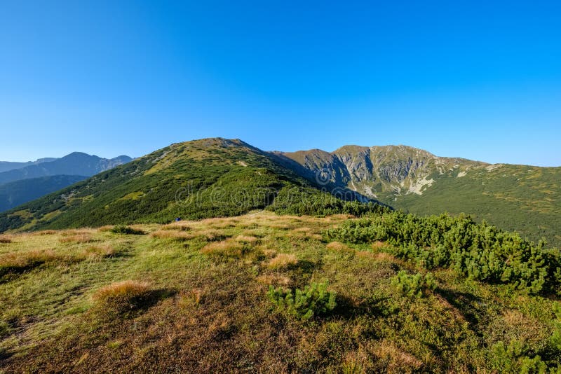 Mlhavé svítání ve slovenských Tatrách se světlými pruhy v f