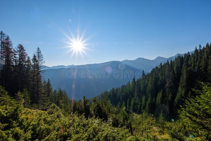 Misty sunrise in Slovakian Tatra mountains with light lanes in f