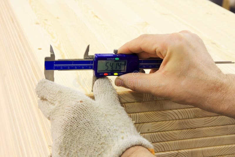 Closeup shot of workers hands measuring wooden item. Closeup shot of workers hands measuring wooden item