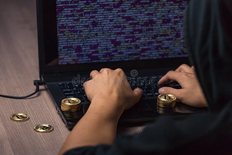 Mit Kapuze Hacker, der Laptop verwendet, um bitcoin zu stehlen lizenzfreies stockbild