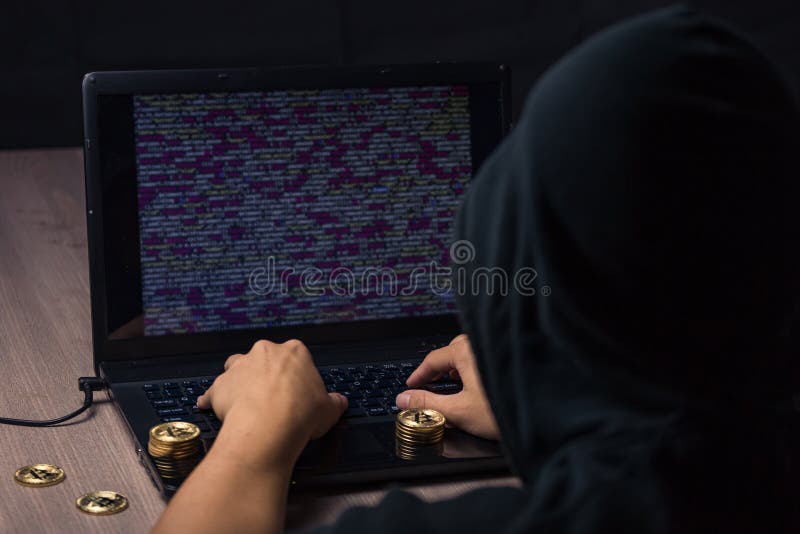 Mit Kapuze Hacker, der Laptop verwendet, um bitcoin zu stehlen stockbild