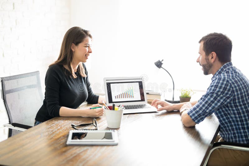 Mitarbeiter, die einen Verkaufsbericht besprechen stockfotografie Mitarbeiter, die einen Verkaufsbericht besprechen stockfotografie