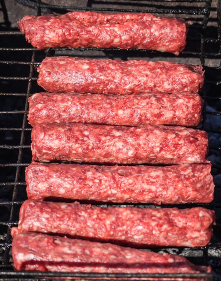 Mititei di Moldavo e cucinato sulla griglia nel fumo immagini stock Mititei di Moldavo e cucinato sulla griglia nel fumo immagini stock