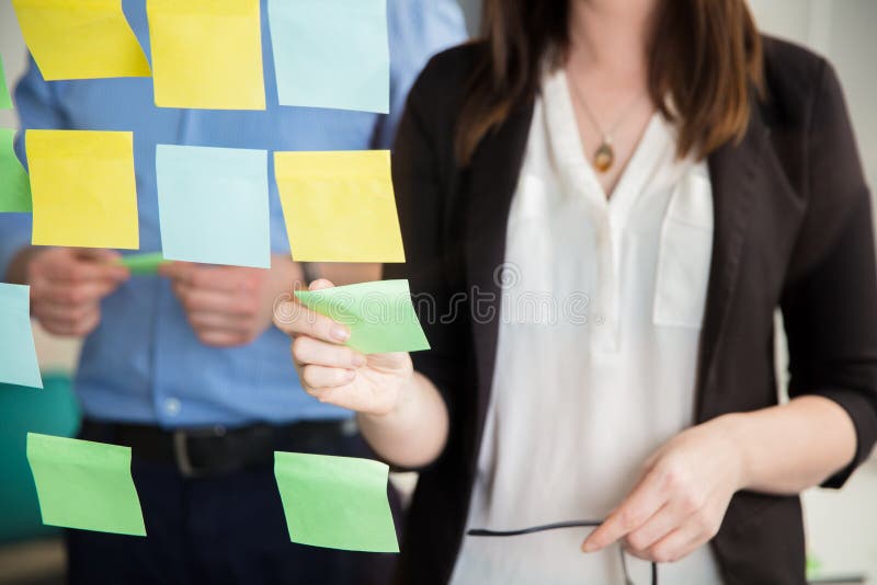 Mittelteil von Geschäftsfrau-Sticking Note On-Glas durch Exekutive stockbild Mittelteil von Geschäftsfrau-Sticking Note On-Glas durch Exekutive stockbild