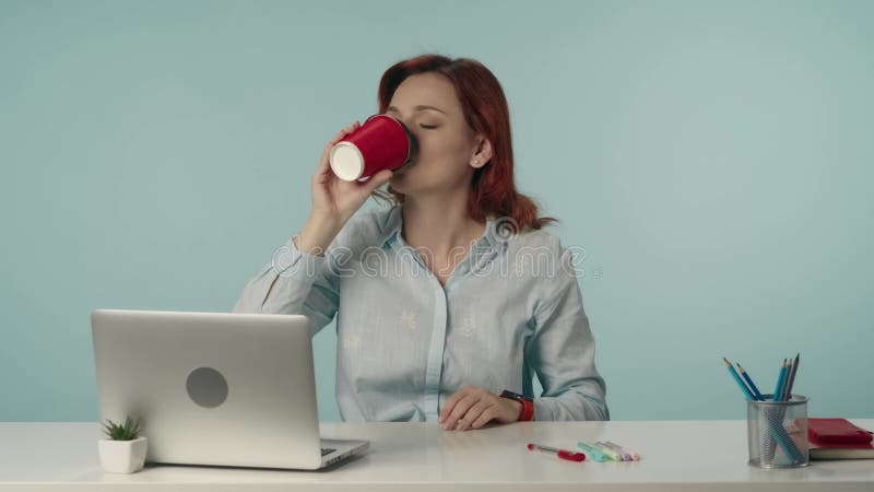 Mittleres isoliertes Video einer jungen müden Frau, die sich streckt und ihren Hals massiert, dann ihren Kaffee trinkt und