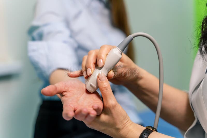 Midsection of radiologic technician scanning female patient& x27;s hand. Midsection of radiologic technician scanning female patient& x27;s hand.