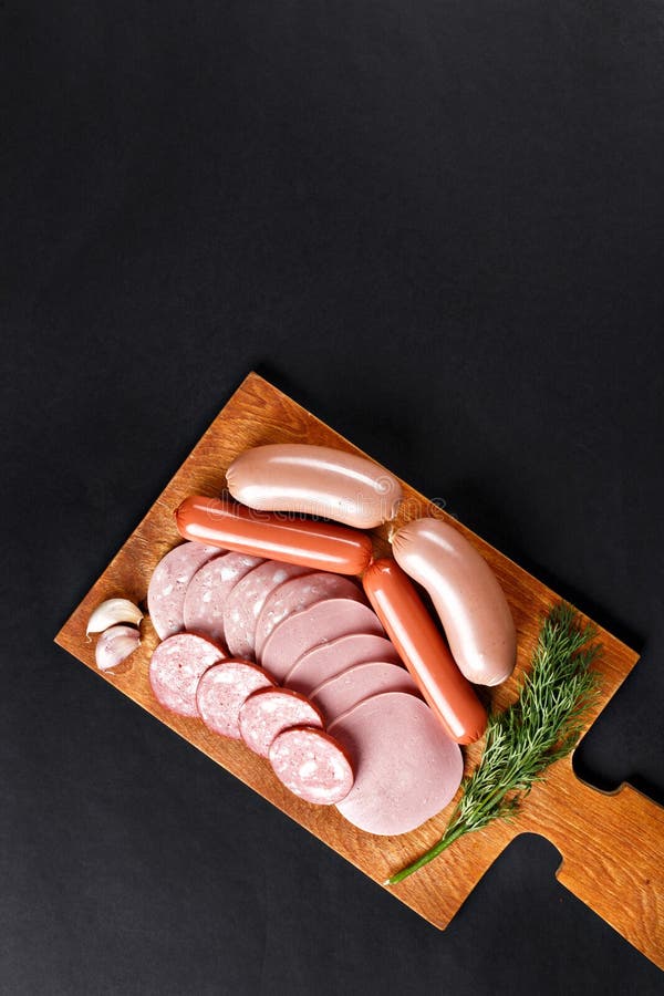 Mix of boiled sausage slices on cutting board stock photos Mix of boiled sausage slices on cutting board stock photos