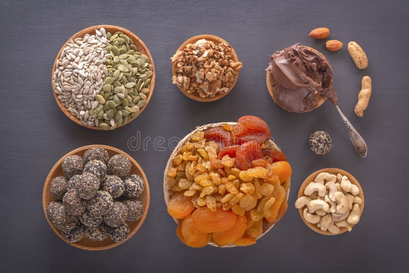 Mix of Dried Fruits, Energy Bites, Chocolate Paste and Nuts on a Dark