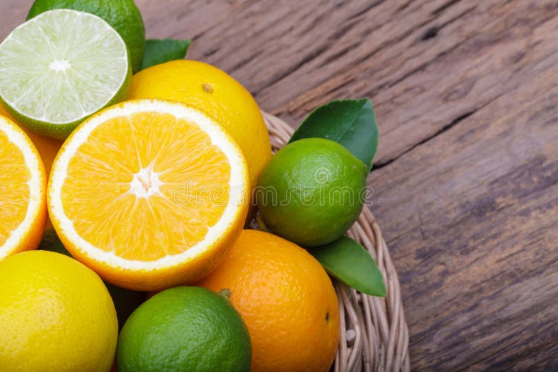 Mix of fresh citrus fruits in basket on wood stock photo Mix of fresh citrus fruits in basket on wood stock photo