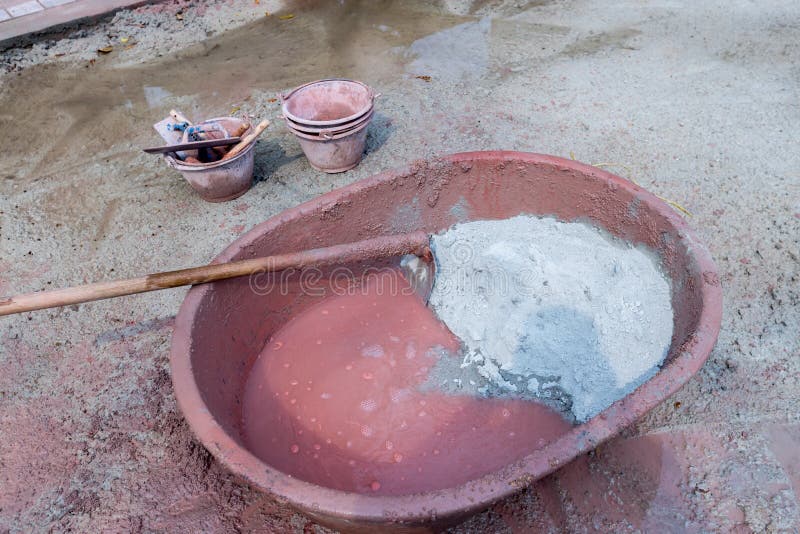 Mixed cement in the bowl. Builders are pouring out of sacks of cement mortar with stone. Mixing a cement in salver for applying co royalty free stock photos Mixed cement in the bowl. Builders are pouring out of sacks of cement mortar with stone. Mixing a cement in salver for applying co royalty free stock photos