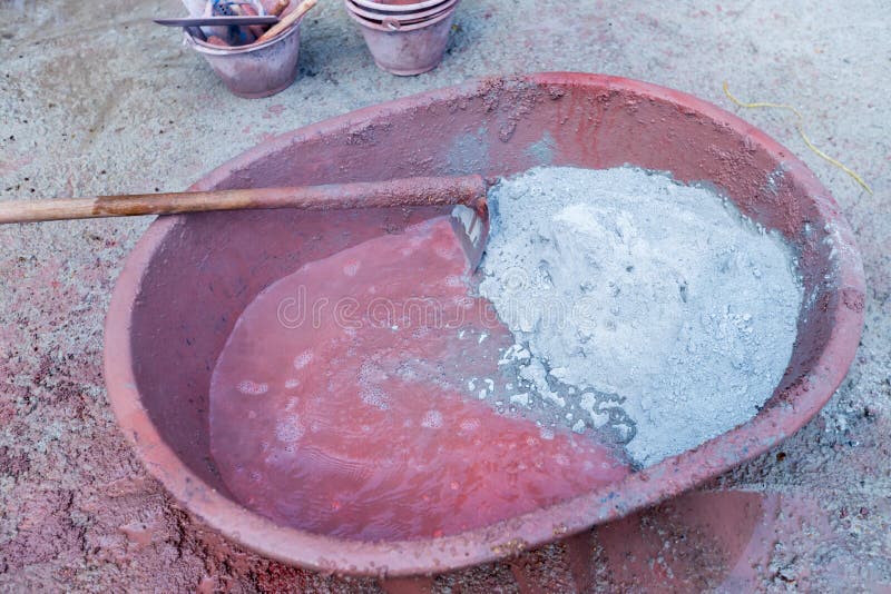 Mixed cement in the bowl. Builders are pouring out of sacks of cement mortar with stone. stock photo Mixed cement in the bowl. Builders are pouring out of sacks of cement mortar with stone. stock photo