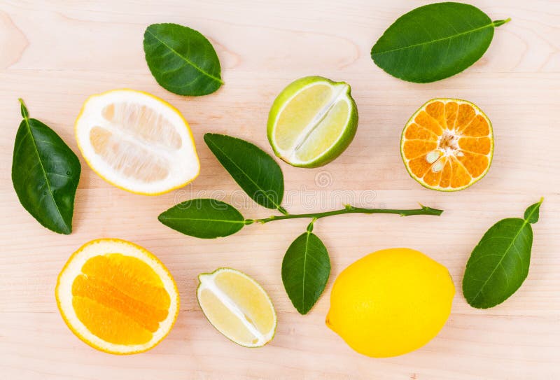 Mixed citruses fruit oranges, lemon and lime on wooden background with orange leaf.
