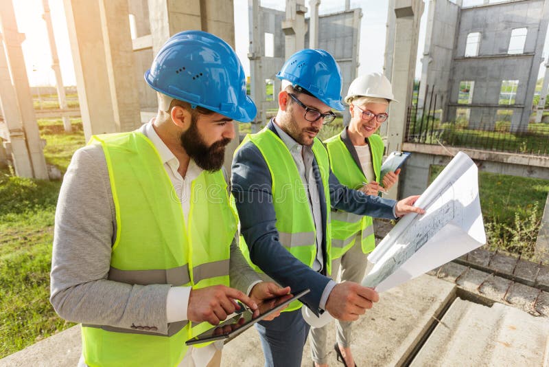 Mixed group of young architects and civil engineers or business partners meeting on a large construction site stock images