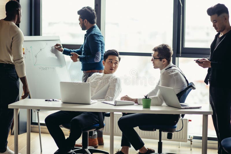 Mixed race business men in open space office interior with a panoramic window royalty free stock photo