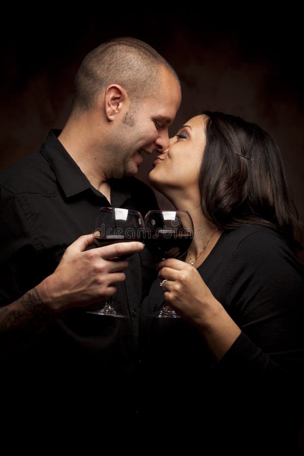 Mixed Race Couple Flirting Holding Wine Glasses stock photo Mixed Race Couple Flirting Holding Wine Glasses stock photo