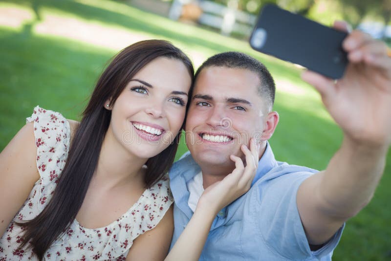 Пара фотографируется на белом фоне. Выходной с любимым в парке. Кадры как люди фотографируются вдвоем.