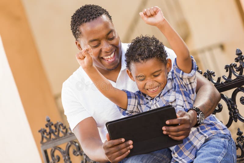 Mixed Race Father and Son Using Touch Pad Tablet royalty free stock images Mixed Race Father and Son Using Touch Pad Tablet royalty free stock images