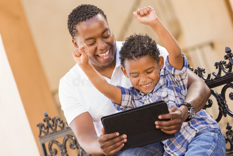 Mixed Race Father and Son Using Touch Pad Tablet