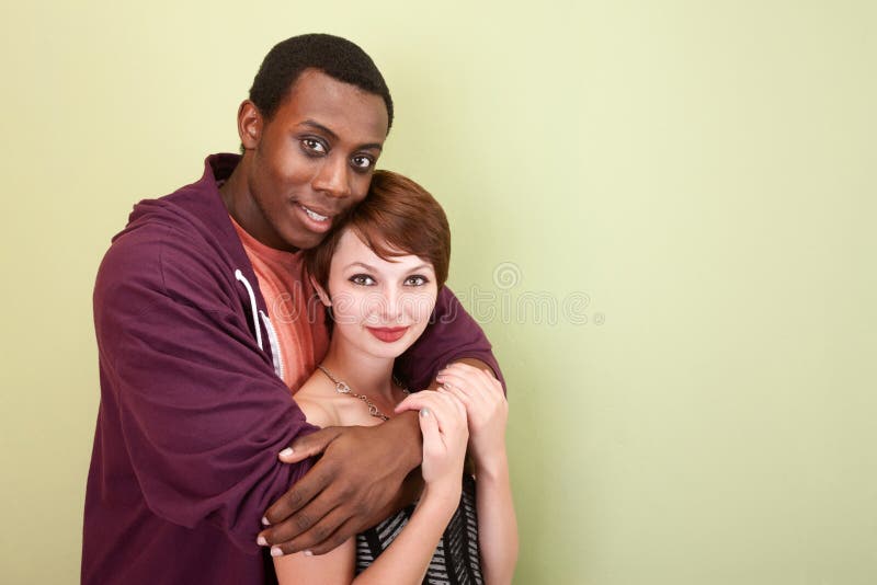 Mixed race teen couple hugging