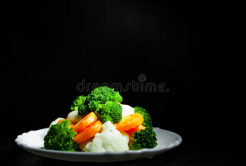 Mixed vegetables. cauliflower, broccoli and carrots in plate on the old dark wooden background stock images Mixed vegetables. cauliflower, broccoli and carrots in plate on the old dark wooden background stock images