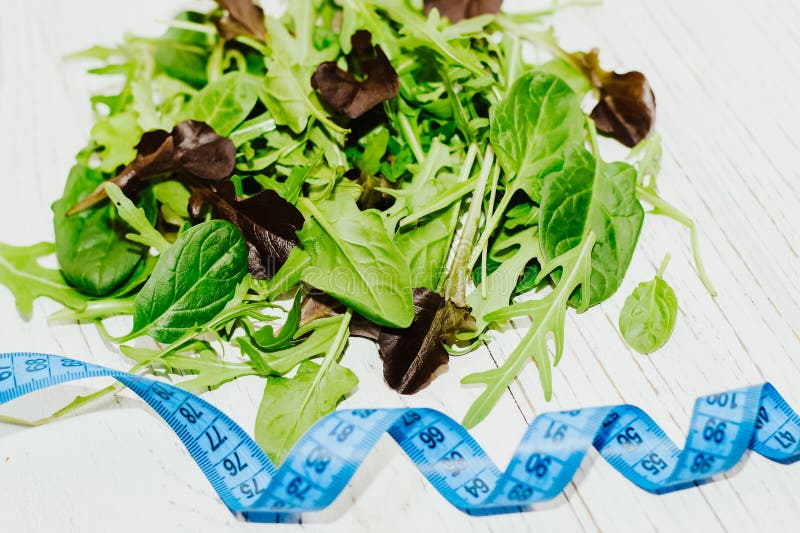 A mixture of lettuce leaves different types with a centimeter for weight loss on a table. royalty free stock images A mixture of lettuce leaves different types with a centimeter for weight loss on a table. royalty free stock images