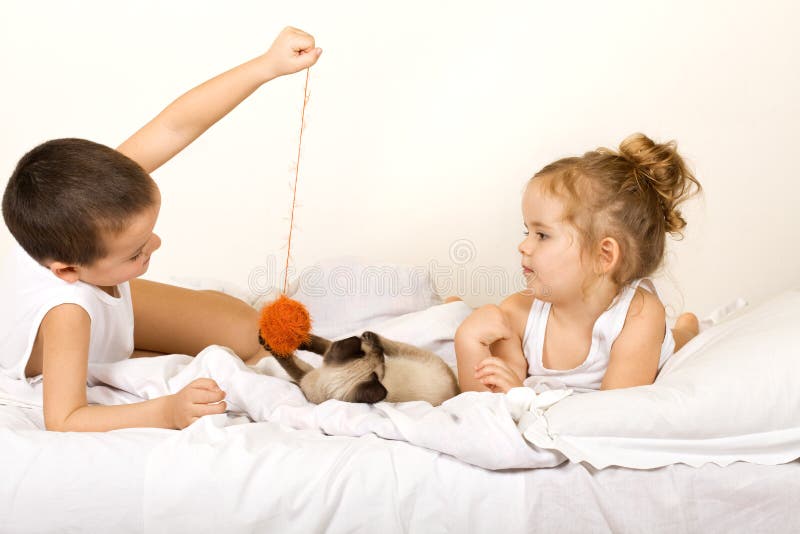 Miúdos que jogam com uma esfera yern e um gatinho imagens de stock royalty free Miúdos que jogam com uma esfera yern e um gatinho imagens de stock royalty free
