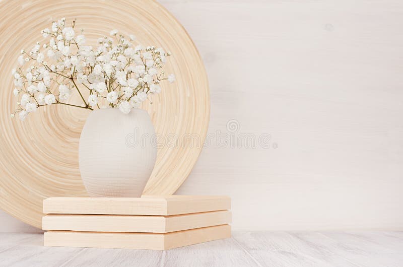 Miękka część domowy wystrój beżowy bambusowy naczynie i biali mali kwiaty w ceramicznej wazie na białym drewnianym tle wnętrze