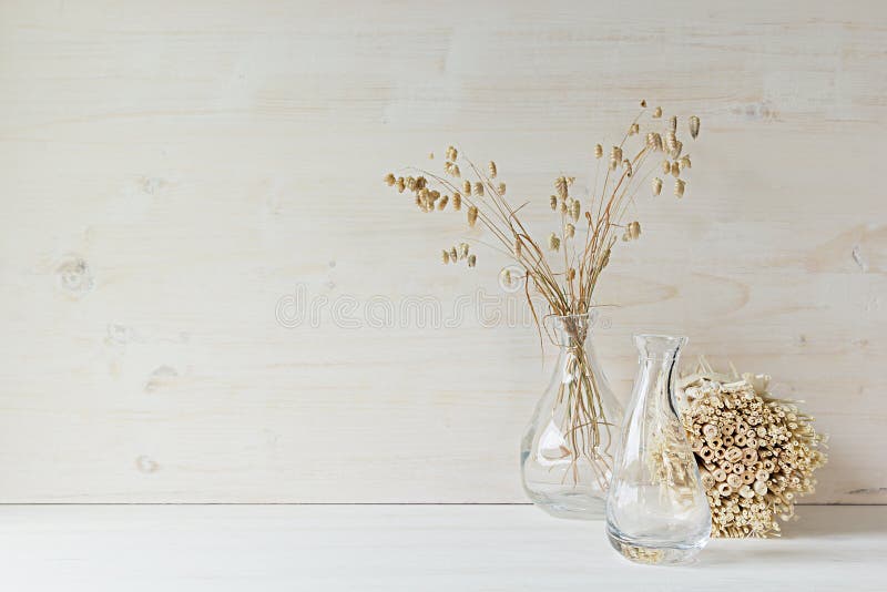Miękka część domowy wystrój szklana waza z spikelets i badylami na białym drewnianym tle